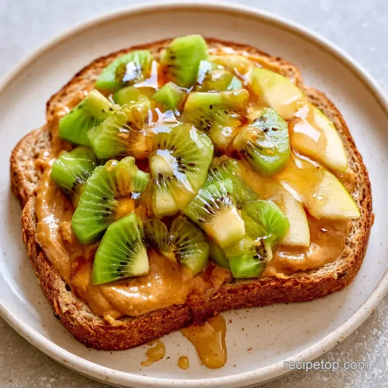 Two neatly stacked fruit sandwiches on a white ceramic plate, garnished with a sprig of fresh mint and sesame seeds.