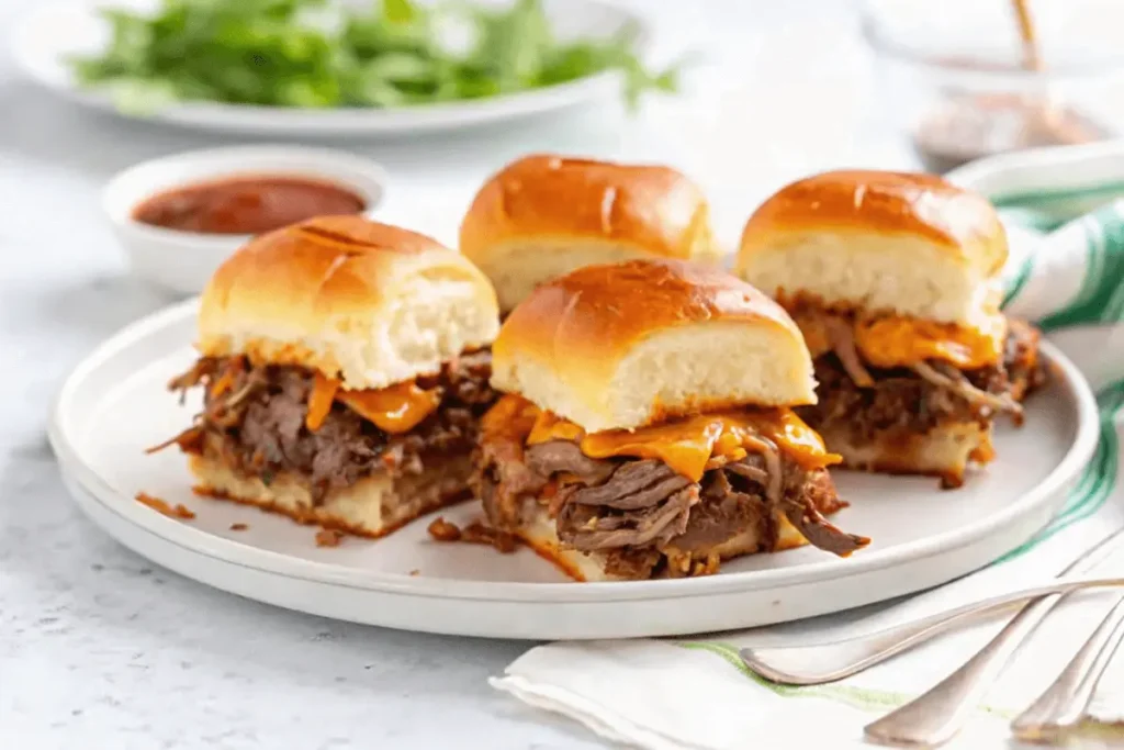  A plate with several roast beef sliders, garnished with fresh herbs and served with a side of coleslaw