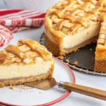 A whole apple pie cheesecake with caramel drizzle and cinnamon sprinkles